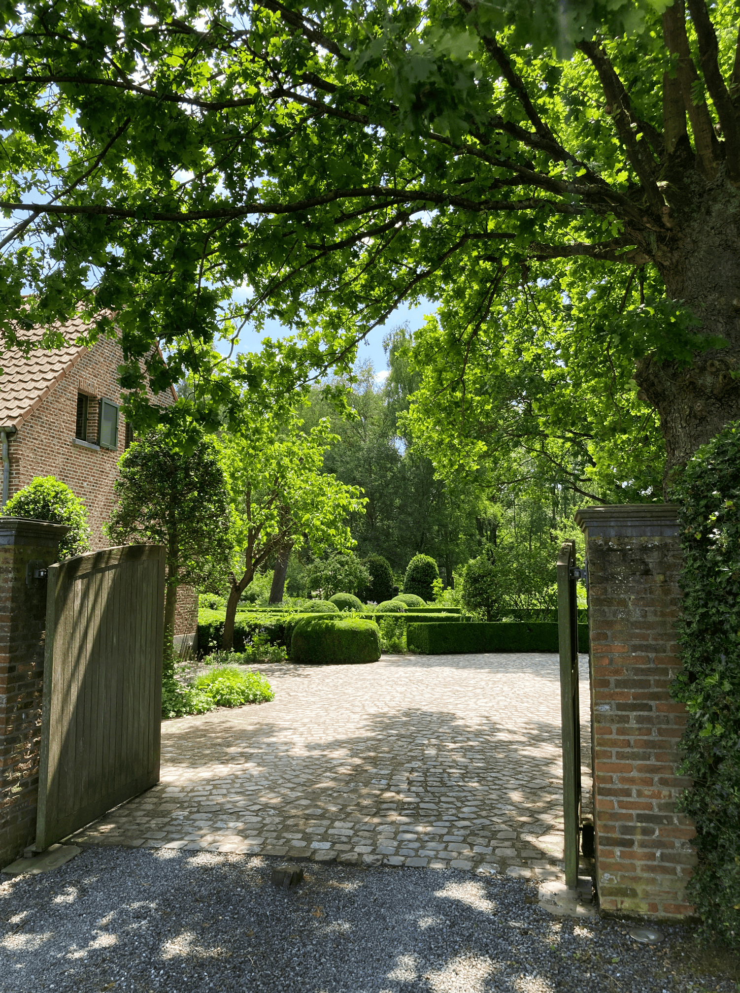 ingang landelijke tuin met tuinpoort onder eikenboom