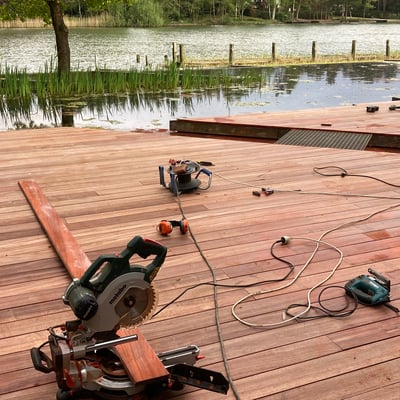 moderne zwemvijver met houten terras en werkmateriaal