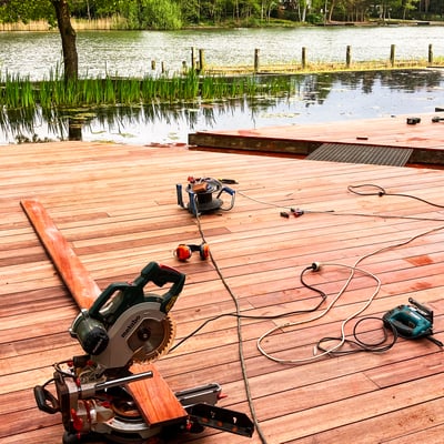 moderne zwemvijver met houten terras en werkmateriaal