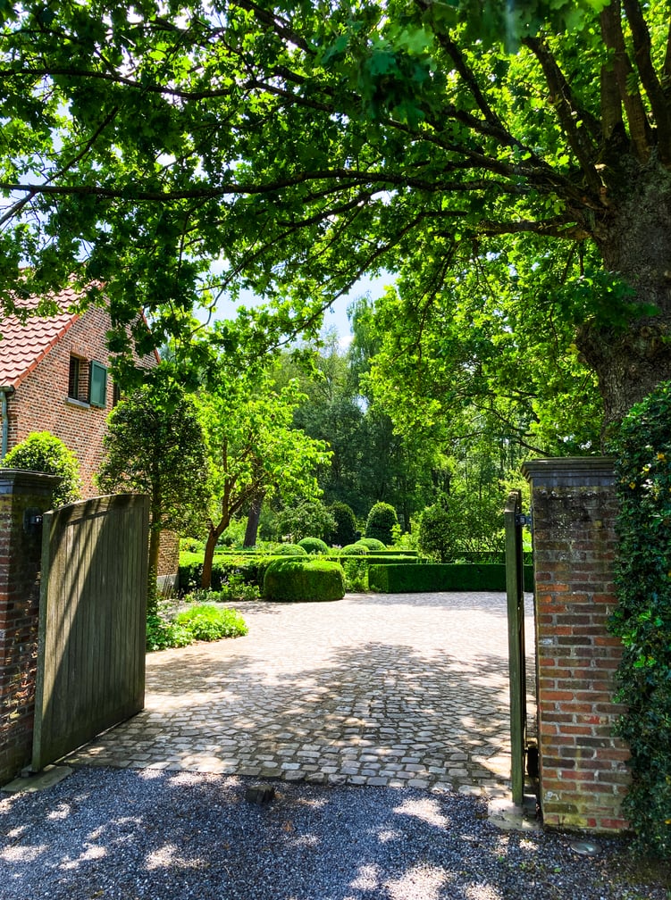 ingang landelijke tuin met tuinpoort onder eikenboom